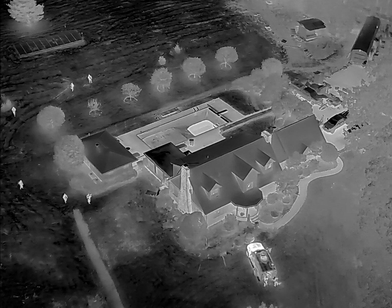 Thermal camera view of a house, yard and parked car from above